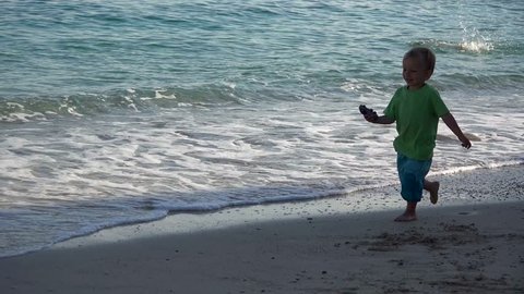 Adorable little boy running on the beach, summer holiday, sunny day