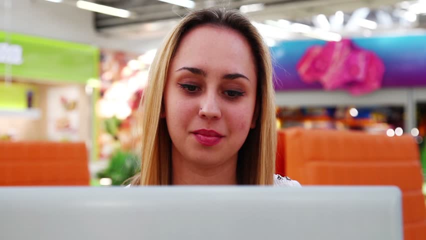 Close-up of a girl looking at laptop monitor in the cafe.