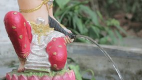 close-up water out off Mother Earth Goddess statue (call in Thai language is Mae Thoranee) 