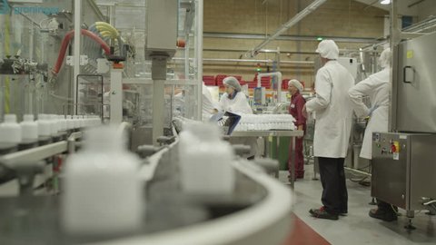 4K People at work. Pharmaceutical manufacturing facility factory. Pharma research and production science. Workers and technicians operate production machinery.  Drugs and cosmetics business industry.