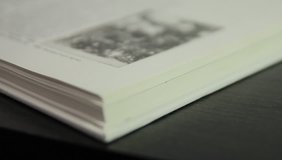 [ungraded] Slow flipping book pages. The book is illustrated with black-and-white photos. Shallow depth-of-field. Source: Canon 7D, ungraded. H.264 from camera without re-encoding. Clip ID: ax1110u