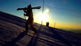 4K Silhouette of a woman with ski in winter mountains sunset. UHD steadycam stock video