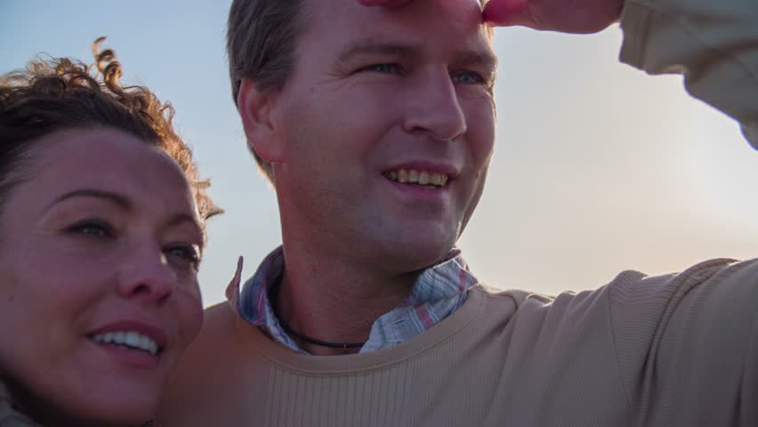 Man looks into the distance. Slow motion close up footage of a couple looking in to the distance on the lookout tower with beautiful view on windy day.