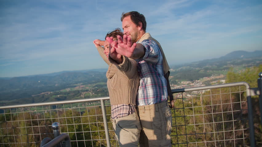 Couple stretch there hands on the sun. Slow motion close up footage of a beautiful couple standing on top of the tower end stretching there hands on the sun with nice background.