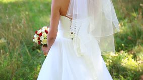 wedding dress with train. beautiful wedding bouquet of flowers in hands of young bride. weddings. young woman. no face. wedding celebration. reception. nature green background. lifestyle couple family