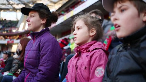 Mother, daughter and son attentive look football match at stadium