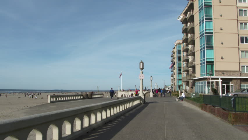 People walking on boardwalk in Seaside, Oregon on beautiful sunny day.