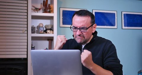 An upset man at his laptop.
