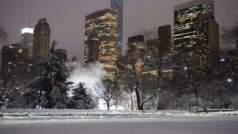 Night time view of Manhattan Skyline with illuminated skyscrapers after snowstorm, as viewed from Central Park, New York City, HD Video