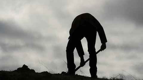  silhouette of man digging a hole with a shovel and wiping the sweat at the end slow motion 2