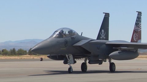 CIRCA 2010s - F-15 and F-16 fighter jets line up and taxi for takeoff in a military exercise.