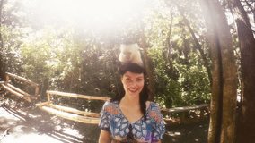 Woman poses with a monkey on her shoulders