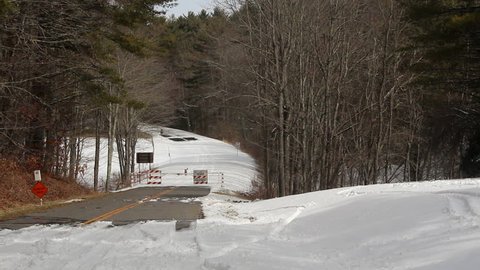 The Blue Ridge Parkway covered in snow with a road closed warning sign gate closed