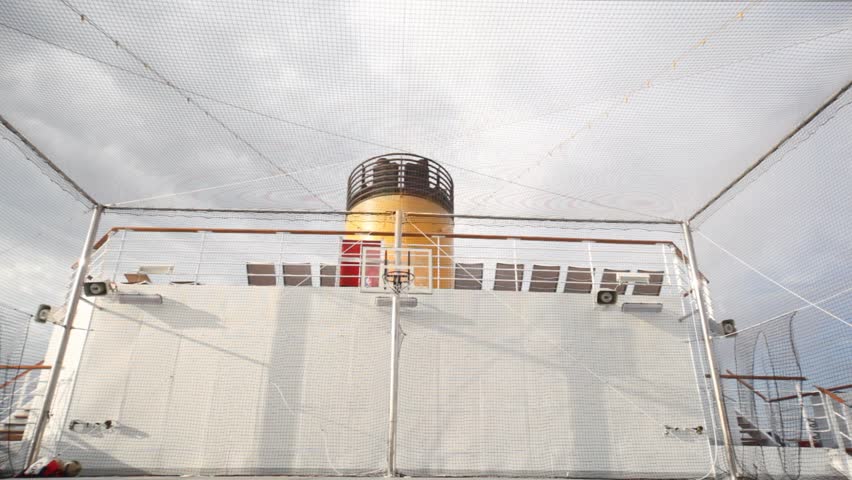 young man plays basketball on open-air playground of cruiser