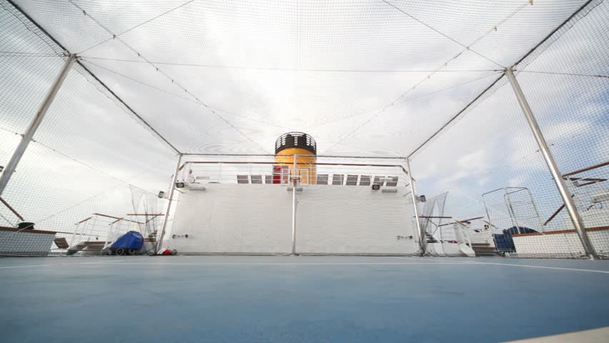 man plays basketball on outdoor playground on cruise ship