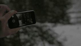 Tourist taking pictures of beautiful winter scene while snowing - slow motion 