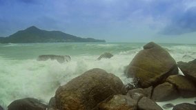 Video FullHD - Foamy breakers. crashing over rounded and eroded boulders under a mostly cloudy sky at this beach in Thailand. Southeast Asia.