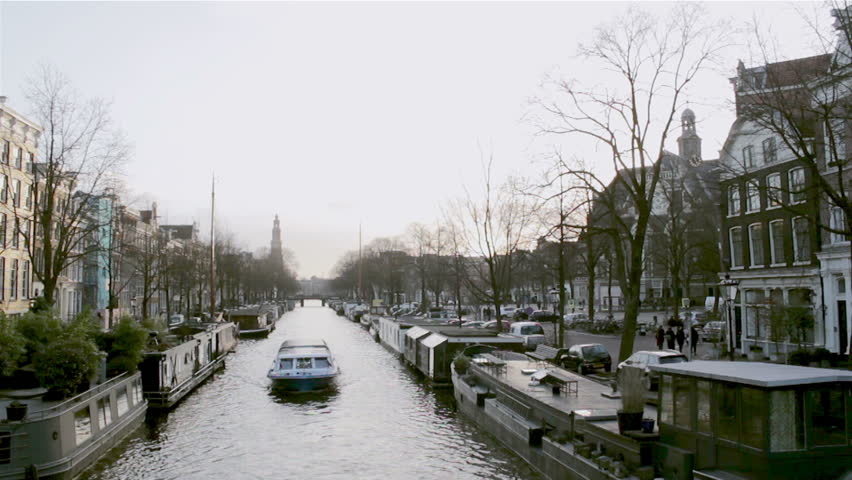 View on one of the Unesco world heritage city canals (Prinsengracht) of Amsterdam whit The Westerkerk Church in the background, The Netherlands.