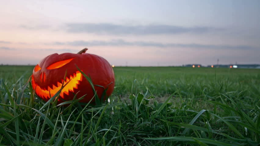Frightening halloween pumpkin glowing after dark, motorized time lapse