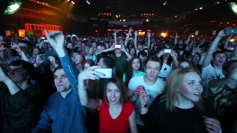 MOSCOW, RUSSIA - APR 05, 2014: Many people shout and photographed on phones in night club Stadium Live during Trancemission party of Radio Record