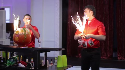 barman show. Two men juggle flaming bottles and breathing fire