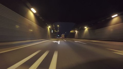 Nightscape drive through Tokyo's modern reclaimed lands on the Bayshore Highway. 3 lane highway tunnel under the Tokyo Bay towards downtown Tokyo.