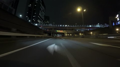 Nightscape drive from Tokyo's modern reclaimed lands via Rainbow Bridge to downtown. Driving on the Bayshore highway through the city lights of Odaiba.