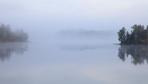 Morning mist on wild forest lake with islands, Karelia, Russia
