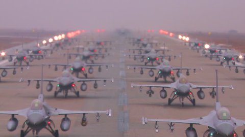 CIRCA 2010s - Zoom back from dozens of Air Force jet aircraft parked and ready on a runway.