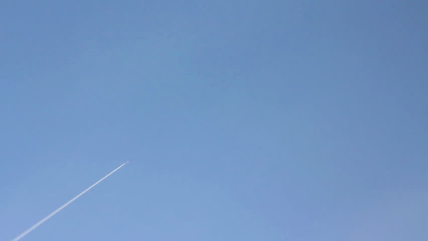 flying airplane with trail in blue sky 
