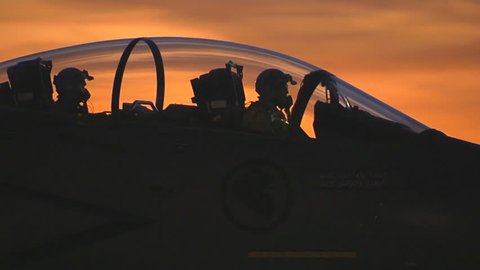 CIRCA 2010s - F-15 fighter jets taxis on a runway at sunset.