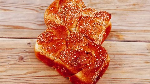 fresh loaf of light wheat bread topped with sesame seeds over wooden table 1920x1080 intro motion slow hidef hd