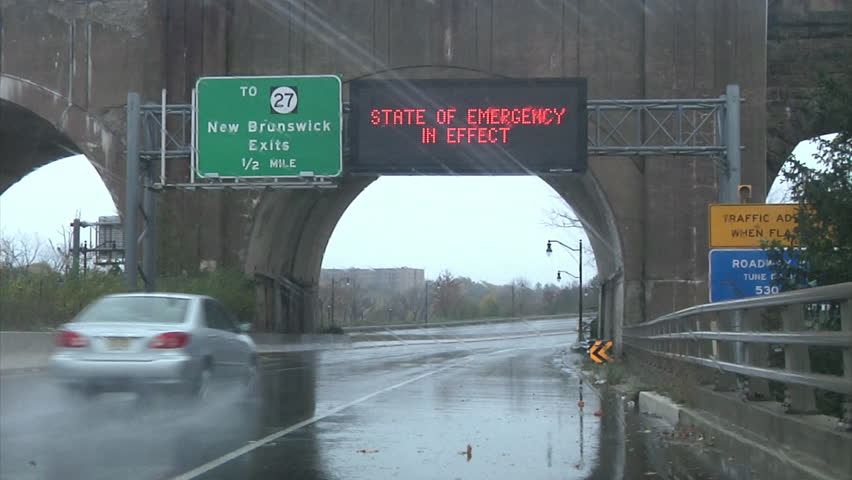 CIRCA 2010s - Waves whip the shore and roads show emergency signs during Hurricane Sandy.