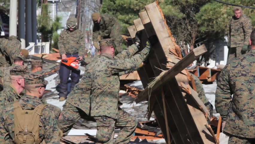 CIRCA 2010s - Marines and army troops search through ruined homes following Hurricane Sandy.