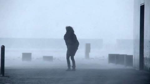 man and woman outside building in raging blizzard snowstorm, Reykjavik, Iceland