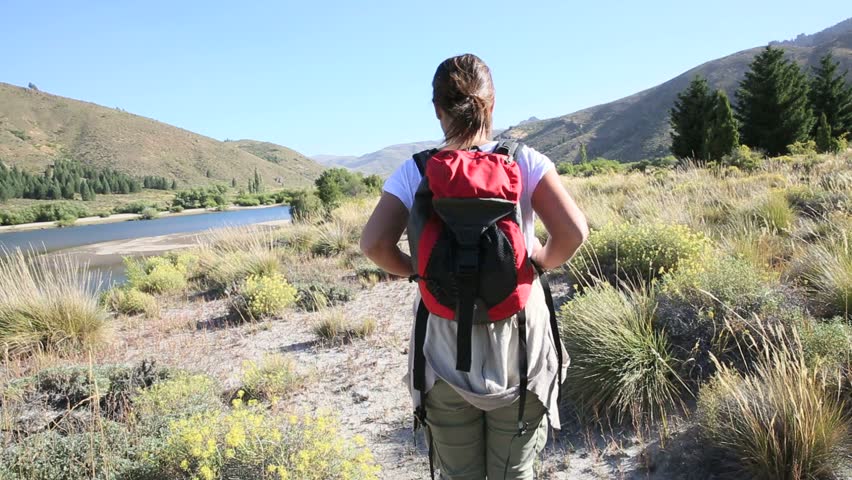 Woman backpacker walking by Limay river, North Patagonia