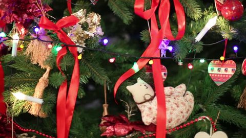 Christmas toys hanging on artificial fur-tree and Illuminated garland