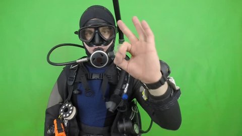 Dive instructor shows sing : OK  also a available on the green screen all of diving sings from course with full dive gear (open water diver) all background from movies separately in portfolio.16 /16