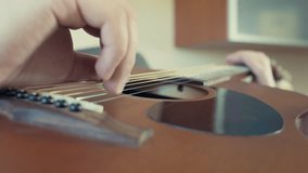 man playing acoustic guitar closeup slow motion