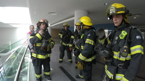 HAIFA, ISRAEL - MARCH 03, 2015: Firefighters rest after searching and finding casualties in a building full of smoke, during a drill of Haifa, Northern Israel Fire Brigade.