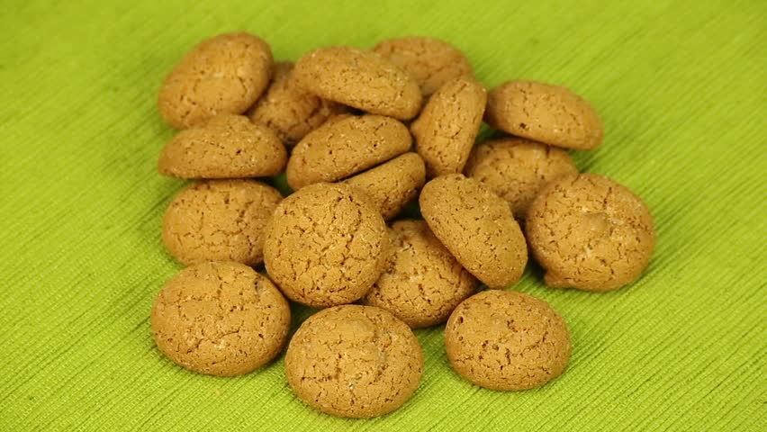 Amaretti biscuits rotate on a green background