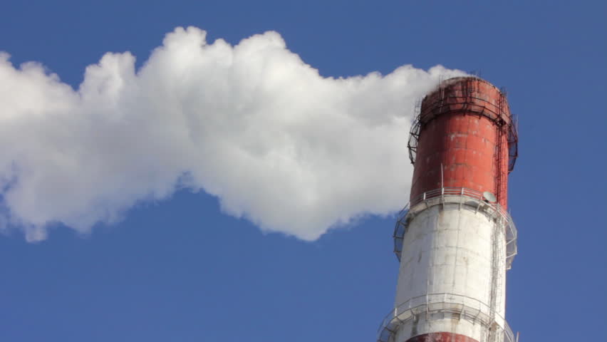 factory chimney with smoke under blue sky