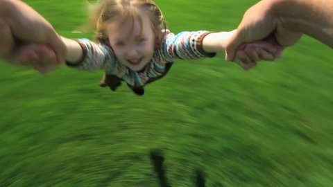 Point-of-view shot of a father spinning his young daughter around in their yard  Video de stock