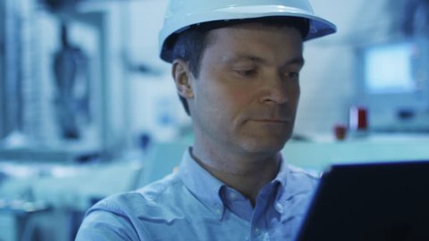 Engineer in Using Tablet in Factory. Shot on RED Cinema Camera in 4K (UHD). Its easy scale, rotate and crop without loosing quality.