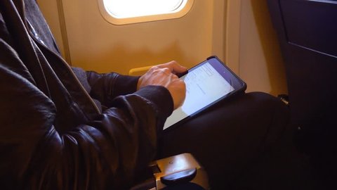 man with tablet on plane स्टॉक वीडियो