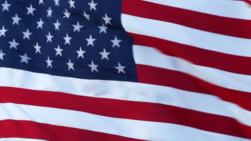 Large flag of the United States, in high wind, closeup.