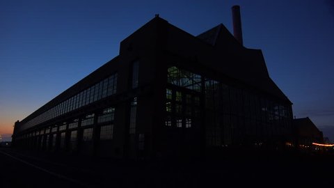 CALIFORNIA - CIRCA 2014 - Wide shot of a large warehouse or factory at dusk or sunset.