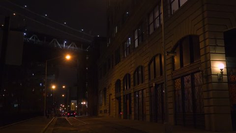 NEW YORK CITY - CIRCA 2015 - Establishing shot of warehouses under the Brooklyn Bridge with subway train crossing.