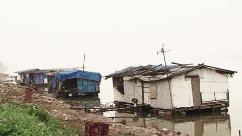 Houses of really poor people on the river. HD 1080p.