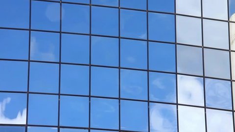 Clouds reflected in windows of skyscraper seamless loop timelapse Stockvideo